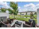 Outdoor patio with wicker furniture and a serene view of the pond at 7030 Summer Holly Pl, Riverview, FL 33578