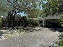 Lovely single-story home with a covered carport, lush landscaping, and a welcoming front entrance at 7601 Pine Hill Dr, Tampa, FL 33617