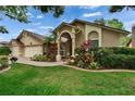 Single-story home featuring an arched entryway, well-maintained landscaping, and a three-car garage at 905 Balsamina Dr, Brandon, FL 33510