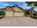 A beige single-story home with a well-kept lawn and three-car garage at 905 Balsamina Dr, Brandon, FL 33510