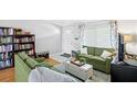 Comfortable living room showcasing two green sofas, a white ottoman, and decorative bookshelves at 9128 Suffield Ct, Tampa, FL 33615