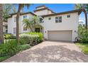 Elegant two-story home with lush landscaping, a red tile roof, and a brick paver driveway at 1122 Shipwatch Cir, Tampa, FL 33602