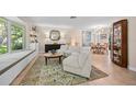 Bright living room features stylish seating, large windows, and views into the dining area at 1235 Nelson St, Dunedin, FL 34698