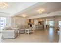 Spacious, bright living room with tile flooring and ample seating flowing into a well-equipped kitchen at 1247 Overcash Dr, Dunedin, FL 34698