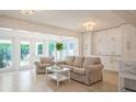 Bright, open living room with tiled floors, neutral furniture, and glass doors to the backyard at 1247 Overcash Dr, Dunedin, FL 34698