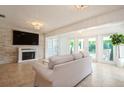 Stylish living room with a stone accent wall, fireplace, tile flooring, and access to the backyard at 1247 Overcash Dr, Dunedin, FL 34698