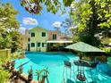 Enjoy this beautiful backyard pool and patio area surrounded by tropical landscaping at 1330 Belcher Dr, Tarpon Springs, FL 34689