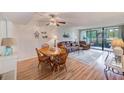 Cozy living room featuring a ceiling fan, dining area, sliding glass doors to patio, and comfortable furnishings at 14130 Rosemary Ln # 4115, Largo, FL 33774