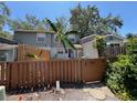 Rear exterior view showcasing a fenced yard, partial view of home, and mature foliage at 14667 Pine Glen Crk # 14667, Lutz, FL 33559