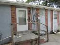 Rear exterior of home featuring back door, combination brick and siding, and wooden railing on small porch at 1785 42Nd S St, St Petersburg, FL 33711