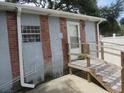 Rear exterior of home with small porch, brick facade, white rain gutters, and small, square window at 1785 42Nd S St, St Petersburg, FL 33711