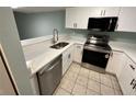 Kitchen featuring stainless steel appliances, white cabinets, and a quartz countertop at 2027 Pine Chace Ct, Tampa, FL 33613