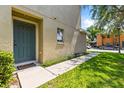 Inviting home entrance with a teal-colored door, sidewalk and lush green lawn at 2032 Sunset Meadow Dr, Clearwater, FL 33763