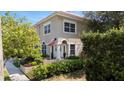 Inviting two-story home with lush landscaping and an American flag displayed at the front entrance at 230 Columbia Dr, Tampa, FL 33606