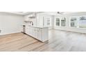 Bright, modern kitchen featuring white cabinets, stainless steel appliances, and light wood-look flooring, flowing into the living area at 315 Dorchester Dr, Venice, FL 34293