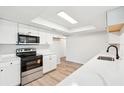 Well-lit kitchen with sleek white cabinetry, stainless steel appliances, and quartz countertops, offering a clean and modern feel at 315 Dorchester Dr, Venice, FL 34293