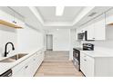 Open-concept kitchen with stainless steel appliances, quartz countertops, and wood-look floors, creating a bright and airy space at 315 Dorchester Dr, Venice, FL 34293