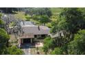 An aerial view of the property, featuring a pool, lush greenery, and a serene, natural backdrop at 34389 Orchid Pkwy, Ridge Manor, FL 33523