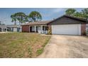 Inviting single-Gathering home featuring an attached garage and a cozy front yard at 4435 Sail Dr, New Port Richey, FL 34652