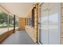 The covered front porch features a front door, window with dark shutters, and painted concrete flooring at 5027 Overton Dr, New Port Richey, FL 34652