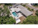Aerial view of a home showcasing the pool, patio area, and lush surrounding landscape at 5201 108Th N St, St Petersburg, FL 33708