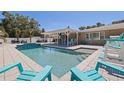Backyard pool area featuring stylish blue chairs, a covered patio and refreshing clear water at 5201 108Th N St, St Petersburg, FL 33708