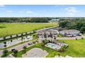 Aerial view of townhomes, pond, pool, parking lot, and landscaped green space at 5496 Riverwalk Preserve Dr, New Port Richey, FL 34653