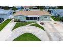 A charming single-story home with a lush, green lawn and unique driveway design from above at 5672 62Nd N Way, St Petersburg, FL 33709