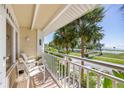 Relaxing balcony with chairs overlooking tropical palms, park, and playground in a tranquil, coastal setting at 611 Destiny Dr # 204, Ruskin, FL 33570