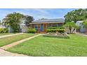 Cozy single-story home with solar panels, a well-manicured lawn, and a charming walkway at 6183 5Th S Ave, St Petersburg, FL 33707