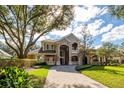 Elegant home featuring a brick driveway, and mature trees at 704 Berrocales De Avila, Tampa, FL 33613