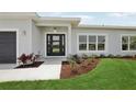 The home features a modern style front door, manicured landscaping, and neutral exterior paint at 718 Desert Hills Way, Sun City Center, FL 33573