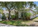 Landscaped single-Gathering home featuring lush greenery, mature trees, and a well-maintained yard at 7603 Wood Violet Dr, Gibsonton, FL 33534
