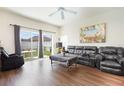 Spacious living room with wood floors, comfortable seating, and sliding glass doors leading to the backyard at 7603 Wood Violet Dr, Gibsonton, FL 33534