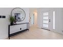 Bright and modern foyer features a stylish console table with round mirror and a frosted glass front door at 8296 33Rd N Ave, St Petersburg, FL 33710