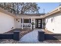 Inviting front porch with decorative tile walkway, modern black door, and cozy seating area at 8296 33Rd N Ave, St Petersburg, FL 33710