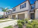 Inviting townhome with an attached garage, enhanced by lush landscaping and a vibrant green lawn at 841 Royal Empress Dr, Ruskin, FL 33570