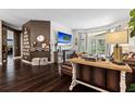 Spacious living room with dark wood floors, designer decor, and large windows for natural light at 9075 Waterash N Ln, Pinellas Park, FL 33782