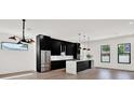 Sleek, modern kitchen with stainless steel appliances, a large island with pendant lighting, and hardwood floors at 908 W Fribley St, Tampa, FL 33603
