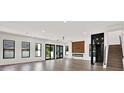 Spacious living room with hardwood floors, a modern fireplace, and large glass doors leading to the backyard at 908 W Fribley St, Tampa, FL 33603
