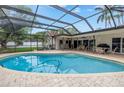 Inviting screened-in pool area with ample seating for entertaining and a clear blue swimming pool at 9674 104Th Ave, Largo, FL 33773