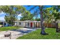 Lovely one-story home boasts a lush front lawn, a covered carport, and a vibrant red front door at 10184 117Th Dr, Largo, FL 33773