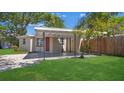 Quaint home with a covered carport, a tidy lawn, and an eye-catching red front door at 10184 117Th Dr, Largo, FL 33773