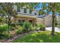 Charming two-story home with a well-maintained front yard and a stone-accented porch at 10833 Breaking Rocks Dr, Tampa, FL 33647