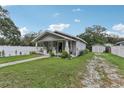 Cozy single-story home with a well-maintained lawn, a white picket fence, and a detached garage at 1206 E Frierson Ave # B, Tampa, FL 33603