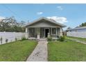Charming single-story home with a cozy front porch, green lawn, and white picket fence at 1206 E Frierson Ave # B, Tampa, FL 33603