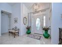 Elegant foyer showcasing a stylish chandelier, decorative mirror, tiled floor, and an ornate bench at 1210 Wolford Dr, Trinity, FL 34655