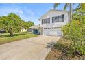 Attractive two-story home with a spacious driveway, lush lawn, and well-maintained landscaping at 12222 Meadowbrook Ln, Hudson, FL 34667