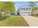Beautiful two-story home with a well-kept lawn, mature trees, and a welcoming facade at 12222 Meadowbrook Ln, Hudson, FL 34667