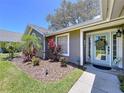Close-up of the front entrance with a charming door, neat landscape, and security features at 1445 Stonehenge Way, Palm Harbor, FL 34683